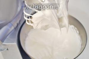 Добавить немного соли и взбивать на максимальной скорости, постепенно всыпая сахарную пудру до устойчивых пиков.