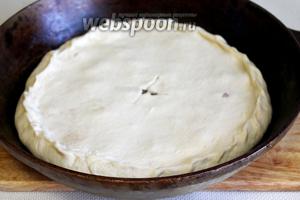 Второй кусок теста также сделать руками тонкой лепёшкой и накрыть пирог, залепляя прочно края, прорезать ножом отверстие для выхода пара, можно ещё сделать проколы вилкой (если тесто поднимется пузырем, то его нужно осторожно проколоть). Поверхность пирога смазать яйцом или маслом.