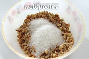 Переложить орехи в миску, всыпать сахар (по вкусу) и добавить ванильный порошок (в оригинальном рецепте в начинку кладётся корица). Перемешать.