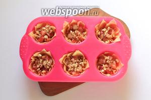 На дно каждой корзиночки выложить яблочную начинку и посыпать измельчёнными обжаренными орехами.