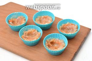 Для придания котлетам нежного сливочного вкуса и особенной сочности и нежности, силиконовые формочки для кексов слегка смазать сливочным маслом. В каждую формочку выложить полную столовую ложку рыбной смеси. Посредине сделать небольшое углубление