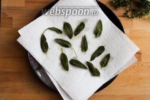 Готовые листики шалфея тут же выньте шумовкой и переложите на бумажное полотенце, чтобы оно впитало лишний жир, а шалфей остался хрустящим.