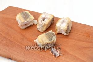 Выложить готовые кусочки рыбы на кухонную доску и нажать с одной стороны на косточку — она легко пройдёт сквозь мякоть рыбы и выйдет с другой стороны. Так мы легко избавимся от костей, оставив кусочки рыбы целыми.