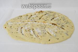 Разрезы посыпаем мукой и слегка растягиваем в стороны. Посыпаем рубленным тимьяном и слегка вдавливаем его руками. Тесто накрываем салфеткой и оставляем ещё на 10 минут.