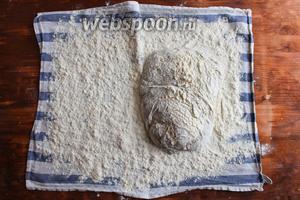 Отставьте тесто в сторону и расстелите на столе чистое сухое кухонное полотенце. Присыпьте его мукой и переложите на него тесто швами вниз.