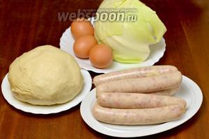 Для данного пирога нам понадобится половина указанной в ингредиентах порции дрожжевого теста холодного приготовления (500-600 г), сделанного заранее, сырые колбаски с сыром, капуста, яйца, соль, подсолнечное масло.