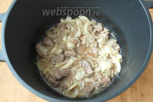 В казан налить подсолнечное масло и хорошо разогреть. Положить мясо и немного обжарить, добавить лук нарезанный полукольцами. Жарить до золотистого цвета помешивая.