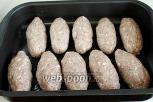 Сформовать продолговатые котлетки, каждую тоже хорошо выбивая руками при формовке. Поставить в нагретую до 200°C духовку на 20 минут, смазать маслом и запекать до зарумянивания.