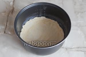 Кастрюльку мультиварки смазываем небольшим кусочком сливочного масла. Переносим в неё одну лепёшку из теста, немного приминаем пальцами и делаем бортики сантиметра 3-4.