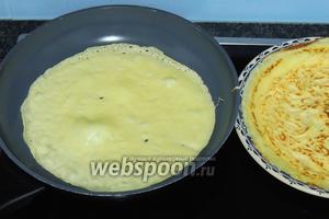 Смазываем каждый раз горячую сковороду с антипригарным покрытием кусочком масла. Наливаем сразу тесто в сковороду, толщиной около 1-2 мм, дадим тесту растечься по всему дну и выпекаем несколько секунд, как только тесто будет само отлипать от дна, можно его переворачивать на другую сторону. И ещё несколько секунд выпекаем. Складываем омлетики на горячую тарелку и накрываем, чтобы не остывали.