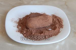 Какао-порошок (30 г) смешиваем с сахарной пудрой (20 г). Обволакиваем каждое пирожное в панировке.