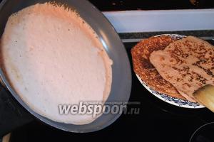 Очень горячую сковороду смажем малым количеством сливочного масла и наливаем половник теста. Сковороду сразу наклоняем в разные стороны, тем самым даём тесту вольно растечься по дну.