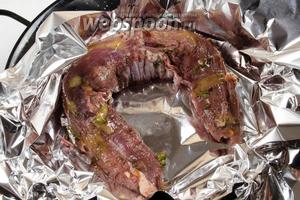 Мясо обтереть от маринада. Выложить на сковороду в фольгу. Смазать верх небольшим количеством мёда (для получения легкой корочки).