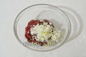 Лук измельчаем максимально мелко, можно пропустить через мясорубку с крупной сеткой. Высыпаем его к говяжему фаршу.