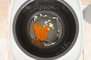 В мультиварку налить масло, бросить нарезанный чеснок и когда масло разогреется, красный перец, немного обжарить.