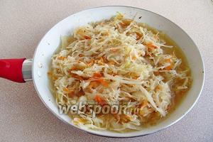 Выложить рёбрышки в миску и накрыть крышкой. В мясной сок, оставшийся на сковороде, добавить 35 мл масла, выложить квашеную капусту и залить её 1 стаканом бульона.