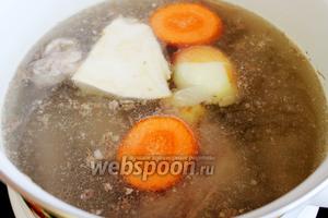 Как закипит, снять пену и добавить коренья кусками, можно их припечь на сухой сковороде или плите. Варить около 3 часов.