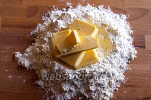 Насыпьте на рабочую поверхность горкой муку и сделайте в ней углубление, порежьте на кубики сливочное масло, а лучше вообще его натереть на крупной тёрке.
