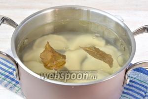 Воду довести до кипения. Добавить соль, 2 лавровых листа и 2 столовых ложки подсолнечного масла. Выложить вареники в кипящую воду. Сразу помешать деревянной ложкой, чтобы вареники не прилипли к горячему дну.