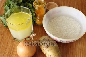 Для супа понадобятся бульон куриный, рис, лук, масло топлёное, свежая зелень (у меня кинза), картофель, щепотка куркумы и соль. Чтобы рис быстрее приготовился, я его предварительно замочила в тёплой (не горячей) воде на 5-10 минут.