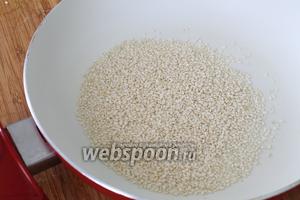 В сухую сковороду всыпать 4 столовые ложки кунжута (остальные 2 ложки семян оставим для обсыпки изделий) и обжарить на медленном огне периодически помешивая.