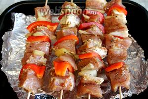 Нанизать на деревянные шпажки мясо, чередуя его с луком и перцем. Поместить над противнем (можно не застилать фольгой). Духовку нагреть на максимум, под гриль поставить противень на 10-15 минут.