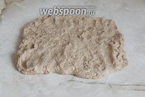 Присыпаем рабочую поверхность оставленной заранее мукой и выкладываем на неё тесто. Разминаем тесто пальцами в форме прямоугольника — одна из сторон должна равняться длине вашей формы. Моя форма 21 см в длину и 11 см в ширину.