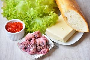 Для того чтобы приготовить вкусные бутерброды с осьминогами и красной икрой понадобится сливочное масло, осьминоги, батон, листья салата и икра красная.
