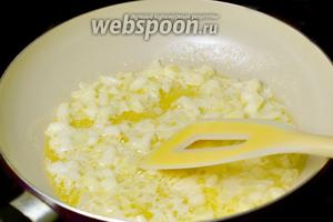 Распускаем на сковороде сливочное масло и на маленьком огне даём луку размягчиться и стать прозрачным.