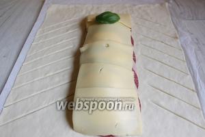 Сверху закрываем твёрдым сыром и опять базиликом. Нарезаем также по бокам тесто на полоски . Делаем их вот таким образом.