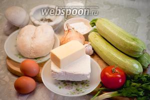 Для приготовления пирога с куриным филе, кабачками и творогом нам понадобятся: отварное куриное филе, кабачки, творог, молоко, твёрдый сыр, яйца, мука, лук, чеснок, помидор, зелень, морская соль, специи, растительное масло для жарки.