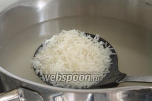 Пока обжариваются кусочки курицы, рис положить в кипящую сильно подсоленную воду. На 3 стакана риса надо взять 3 литра воды и кипятить в большой кастрюле. Не забываем перемешать, чтобы рисинки не прилипли ко дну кастрюли и не слиплись между собой. Рис надо варить до состоянии альденте, то есть рис должен быть не сильно сваренным, но и не сырым. Надо постараться поймать тот самый момент.