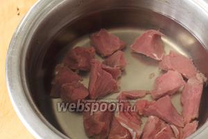 Сначала надо отварить мясо. Нарезать говядину на небольшие кубики, положить в кастрюлю и залить холодной водой. Довести до кипения, снять пену и варить на маленьком огне до готовности. В конце посолить.