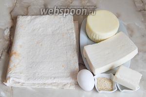 Для приготовления пирога-улитки нам понадобятся следующие продукты: тонкий армянский лаваш, сыр сулугуни, брынза, яйцо куриное, масло сливочное, кунжут.