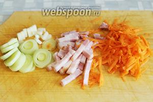 Нарезать белую часть лука-порея, кусочек стебля сельдерея, копчёную грудинку, натереть на тёрке морковь.
