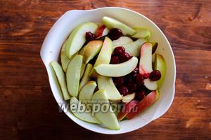 Сложите дольки яблок в миску и добавьте вишню. Если вы используете замороженную вишню, то сначала её следует разморозить, слить весь сок, а после этого добавить к яблокам. Сбрызнуть лимонным соком.