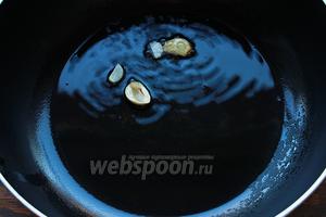 Ароматизировать масло чесноком, для этого опустить разрезанный вдоль зубчики чеснока, в раскалённое масло, убрать, как только начнёт менять цвет.