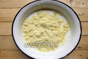 Вводим постепенно кукурузную муку, смешанную с разрыхлителем. Сначала ложкой вымешиваем тесто, потом выкладываем на рабочую поверхность и вымешиваем руками. Подсыпаем если нужно муку, пока тесто не перестанет липнуть к руками.