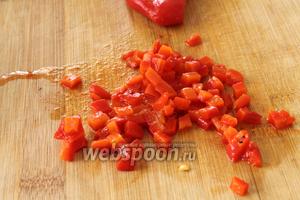 Консервированный перец достать из рассола и нарезать кубиками. Также нарезать кубиками огурцы.