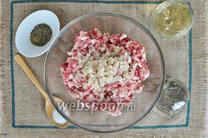 Пропустить через мясорубку чеснок. Добавить в фарш соль, перец, вермут и итальянские травы. И тщательно всё перемешать.