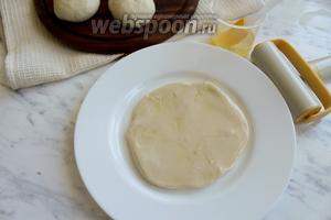 Стол смазать растительным маслом и раскатать каждый шарик теста в лепёшку, выложить на тарелку и смазать каждую растительным маслом.