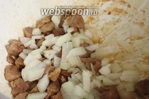 Добавляем к мясу нарезанный на кубики лук и, периодически помешивая, готовим до прозрачности лука.