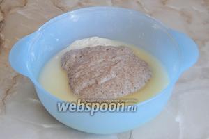 Убираем с большой миски половину муки, а к остальной части добавляем 200 мл сыворотки и опару.