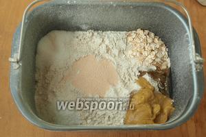 Муку разровнять и по углам добавить соль, сахар, овсяные хлопья, подсолнечное масло и горчицу. В центре сделать небольшое углубление и всыпать дрожжи.