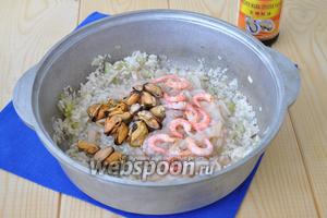 Добавить морепродукты и соевый соус, немного соли по вкусу. Перемешать и готовить пока жидкость от морепродуктов не выпарится и не впитается в рис.