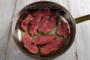 Разогреть сковороду с оливковым маслом 3 ст. л., выложить куски мяса. Не солить! Обжарить на сильном огне в течение 5-7 минут с одной стороны.