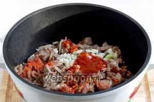 Когда испарится вся жидкость, мясо можно подсолить, добавить острую аджику (у меня из банки, но можно и сухую в специях), чеснок, красный перец молотый, хмели-сунели. Перемешать и тушить всё вместе минут 5.