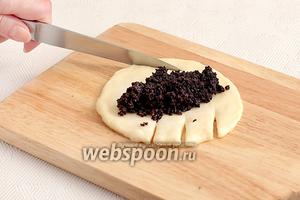 Каждый шарик расплющить в лепёшку, в центр выложить маковую начинку, а по бокам сделать надрезы с двух сторон.