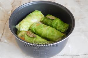 Заливаем голубцы томатным соком, подсаливаем по вкусу, кладём лавровые листики и перец горошком.