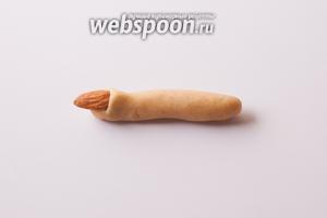 Дальше начинаем в каждую колбаску вставлять миндальный ноготь. Неоднократно читала, что у людей ногти из цельных орешков при выпекании или после выпадают, потом их приходится подклеивать, кому на шоколад, кому на «кровавое» красное варенье… Так вот, мне, оказывается, с самого начала очень повезло, что мне попался рецепт с половинками миндаля, которые нужно не УКЛАДЫВАТЬ ПОВЕРХ теста, а ВДАВЛИВАТЬ в него слегка наискосок, так, чтобы миндаль вошёл под складку теста. Ни разу при этом способе с проблемой выпадения ногтей у печенья не сталкивалась. Я постаралась снять крупно и сбоку, все отчетливо видно? У нашей ведьмы — не какие-то накладные ногти, а самые настоящие, растут ИЗ ПАЛЬЦА, покрыты кожей.
